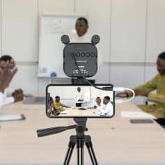 Advanced recording setup with microphone and smartphone, capturing a professional presentation in a modern office or classroom environment.
