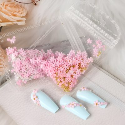 Pink flower-shaped decoration sprinkles with gold beads inside a clear plastic container for nail art at Monalisa Store, perfect for enhancing nail designs and beauty accessories.