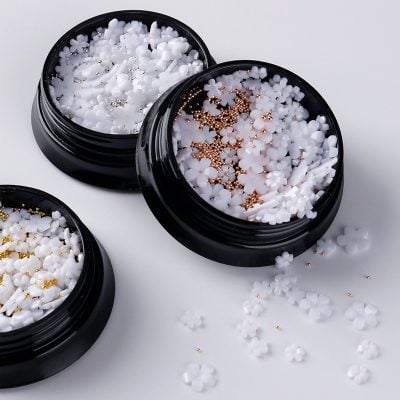 White floral nail art decorations in cosmetic jars for manicure and pedicure, Monalisa Store nail accessories, premium nail art embellishments, perfect for professional or DIY nail designs, high-quality nail decoration supplies.