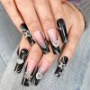 Elegant black and silver nail art with rhinestone embellishments and 3D heart-shaped accents, perfect for stylish occasions.