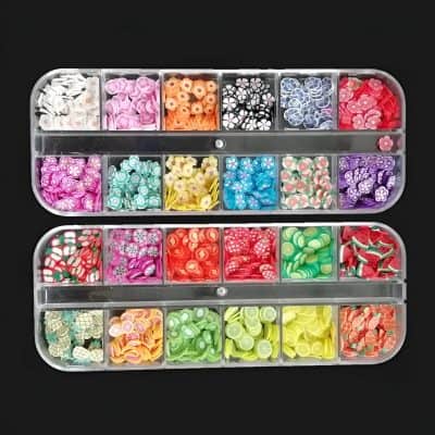 Colorful flower-shaped and novelty nail art embellishments in a clear plastic storage box for professional and salon use.