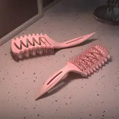 Pink plastic hairbrushes with wide teeth, designed for hair detangling and styling. Perfect for salon use or home haircare routines, combining functionality and modern aesthetics.