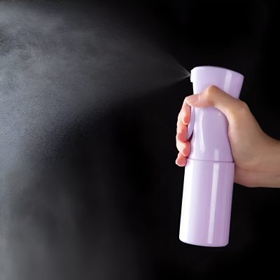 Moisture spray bottle emitting mist, used for skincare or cleansing, held by hand against dark background at Monalisa Store.