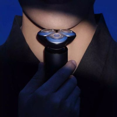 Close-up of a person holding an electric shaver to the neck, with a focus on grooming and personal care. Perfect for promoting men's grooming products and shaving solutions at Monalisa Store.