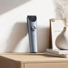 Sleek cordless hair trimmer on wooden surface with minimalist decor in the background.