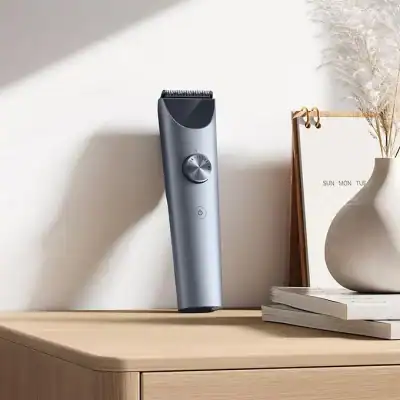 Sleek cordless hair trimmer on wooden surface with minimalist decor in the background.