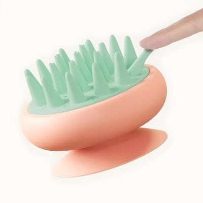 Silicone scalp massager with soft bristles, pink and green, designed for hair and scalp care, ideal for relaxing and stimulating scalp health.