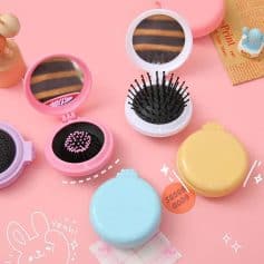 Pink compact mirror with hairpins, round pill case in blue and yellow, and playful decorative elements on a pink background.