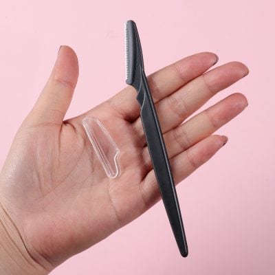 Precision eyebrow shaping tool with tweezers and clear protective cover for professional and at-home grooming. Perfect for hair removal and detailed brow maintenance.