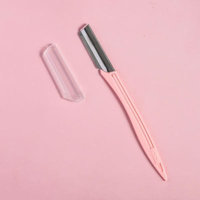 Cosmetic razors for gentle facial hair removal with protective cover on pink background, suitable for at-home skincare.