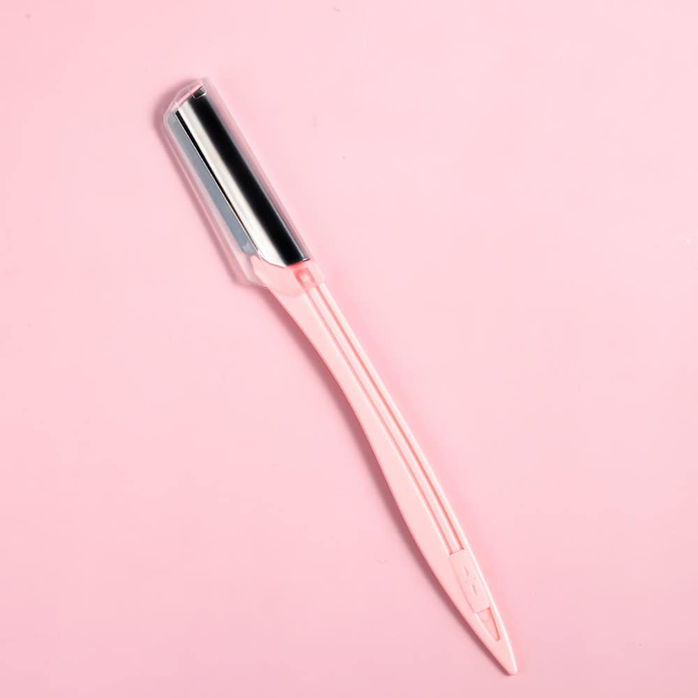 Stylish pink and silver eyebrow razor for precise grooming and shaping, perfect for facial hair removal and skincare routines.