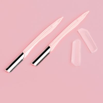 Disposable pink razors for women, with replaceable blade cartridges and transparent protective covers on a pink background. Perfect for skincare and beauty routines.
