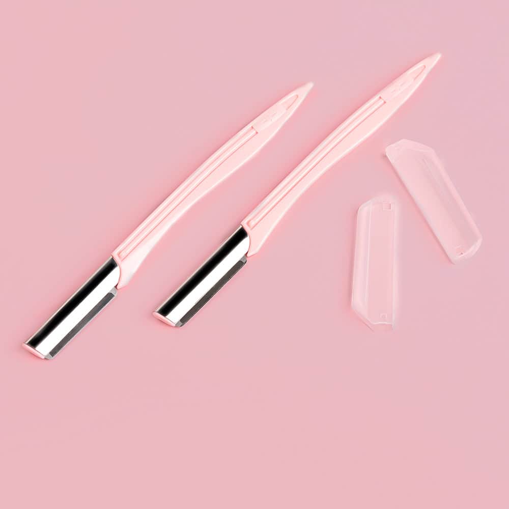Disposable pink razors for women, with replaceable blade cartridges and transparent protective covers on a pink background. Perfect for skincare and beauty routines.