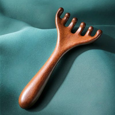 Wooden massage tool on teal fabric background, promoting wellness and relaxation for spa and beauty treatments. Perfect for skincare, massage therapy, and self-care routines.