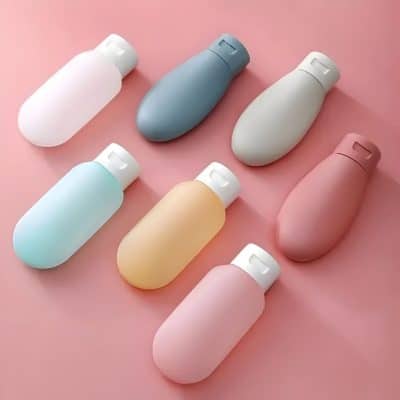 Silicone pill containers in pastel colors on a pink background, ideal for pill storage and medication organization.