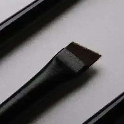 Black eyebrow tint brush for professional cosmetic application or beauty treatment.