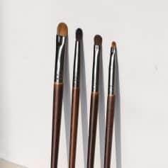 Artistic makeup brushes with wooden handles and silver ferrules, ideal for eye, lip, and face makeup application. Perfect for professional and everyday beauty routines.