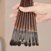 Professional makeup brushes set with wooden handles and various brush sizes for cosmetics application and beauty routines.