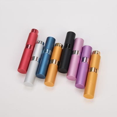 Colorful cosmetic bottles in various shades including red, white, blue, gold, black, purple, and pink, arranged on a white background. Perfect for skincare or beauty product storage.