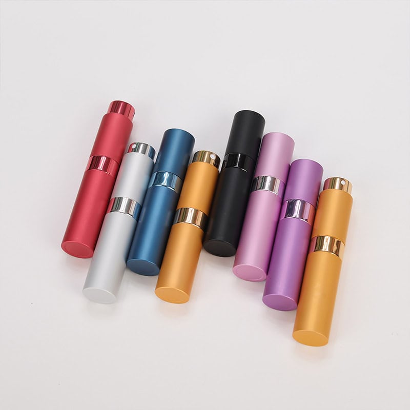 Colorful cosmetic bottles in various shades including red, white, blue, gold, black, purple, and pink, arranged on a white background. Perfect for skincare or beauty product storage.