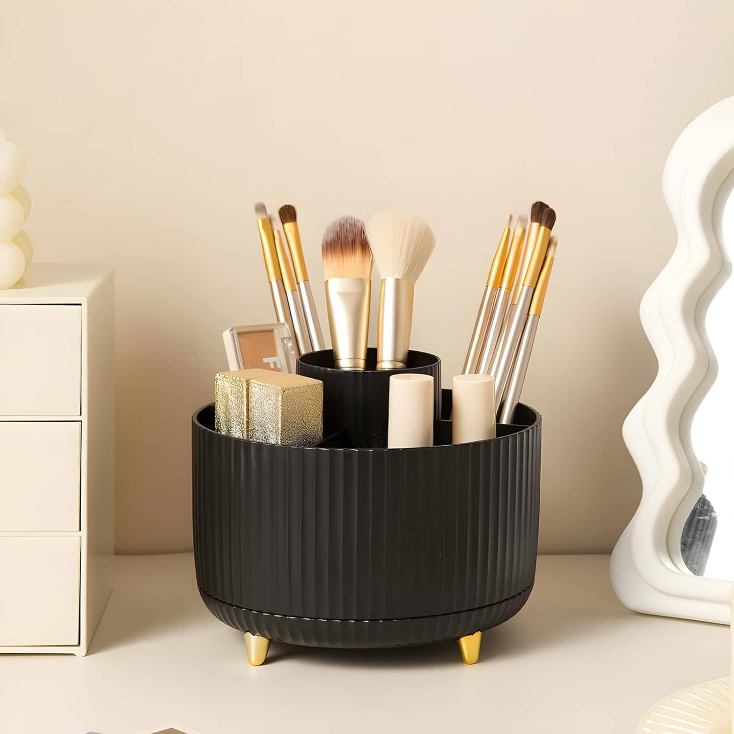Elegant black makeup brush holder with gold-tipped brushes, skincare products, and a decorative mirror, showcasing beauty and skincare essentials on a sleek white vanity. perfect for professional and personal use.