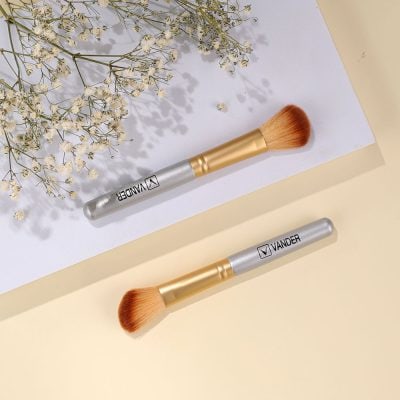 Vander makeup brushes on a pastel surface with baby's breath flowers, showcasing high-quality cosmetic tools ideal for beauty enthusiasts and professional makeup artists.