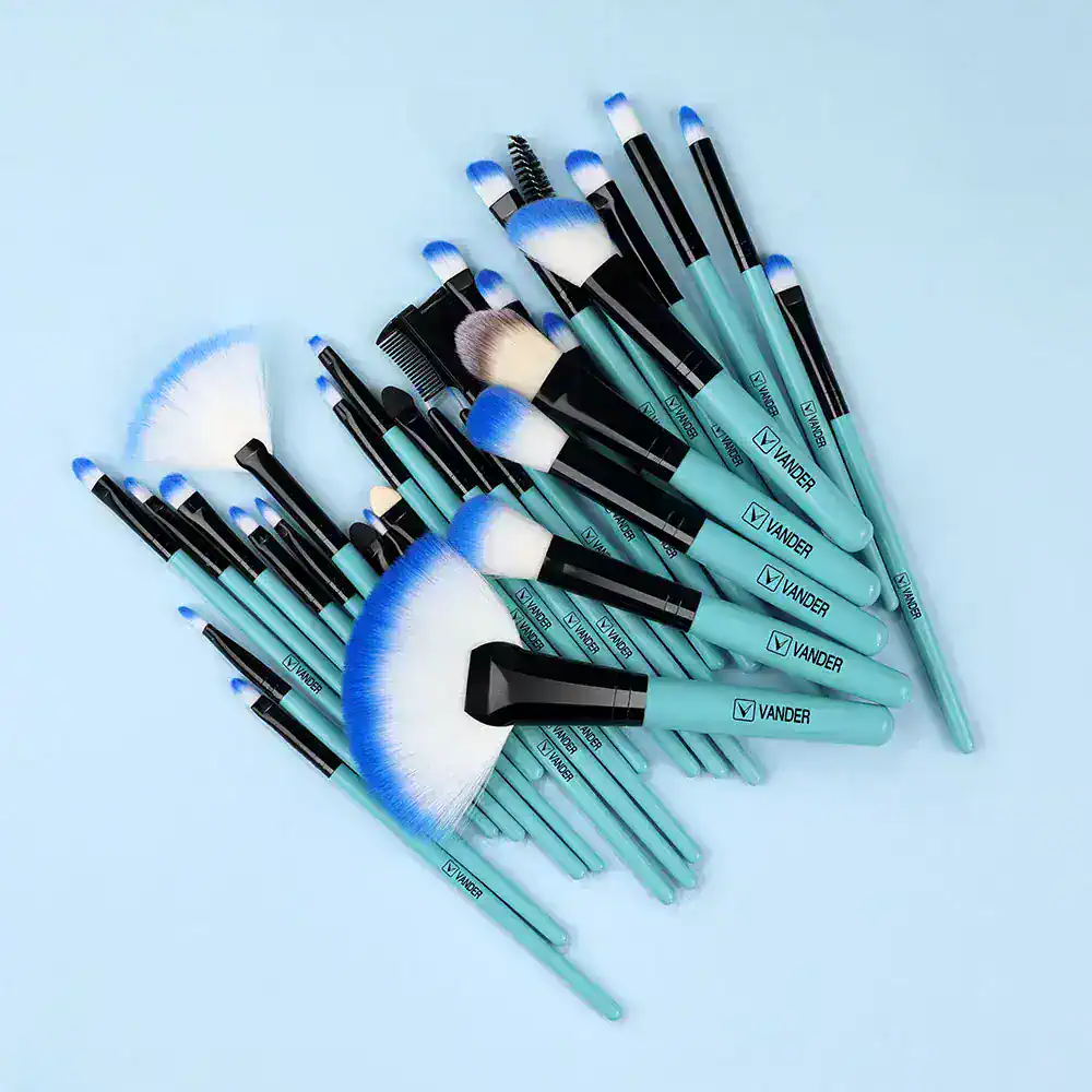 Soft pastel blue makeup brushes set with black handles, including fan, angled, and eyeshadow brushes, for beauty and cosmetic applications. Vander brand cosmetics tools for professional and at-home use.