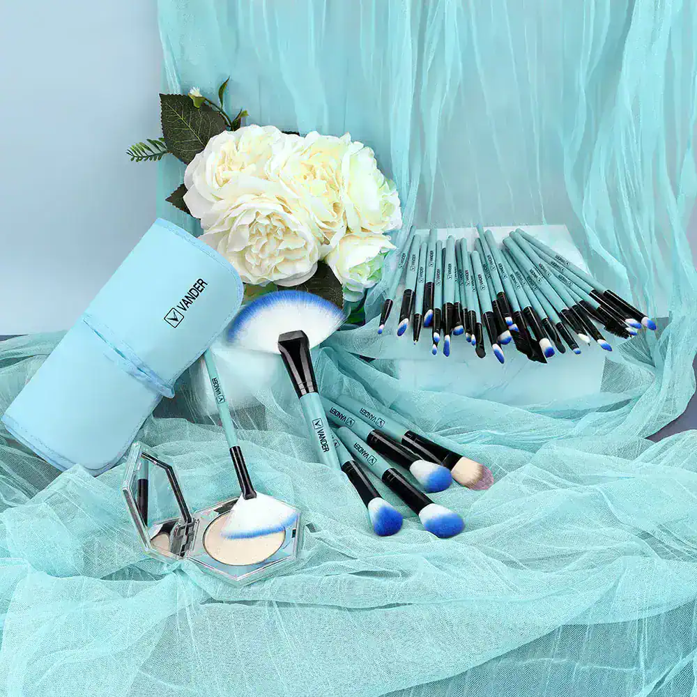 Vander beauty makeup brushes and tools on a soft turquoise fabric with white flowers, ideal for beauty salons, makeup artists, and cosmetic enthusiasts looking for high-quality makeup essentials.