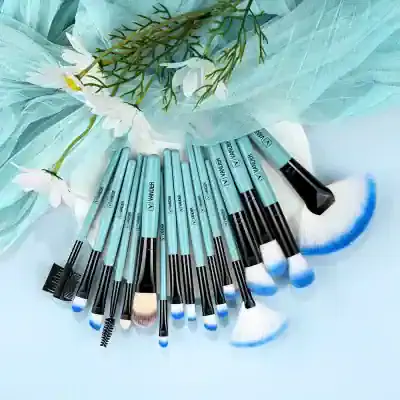 Blue makeup brushes set on white background with flower and tulle decor, ideal for professional cosmetic and beauty salon use, featuring high-quality tools for flawless makeup application.
