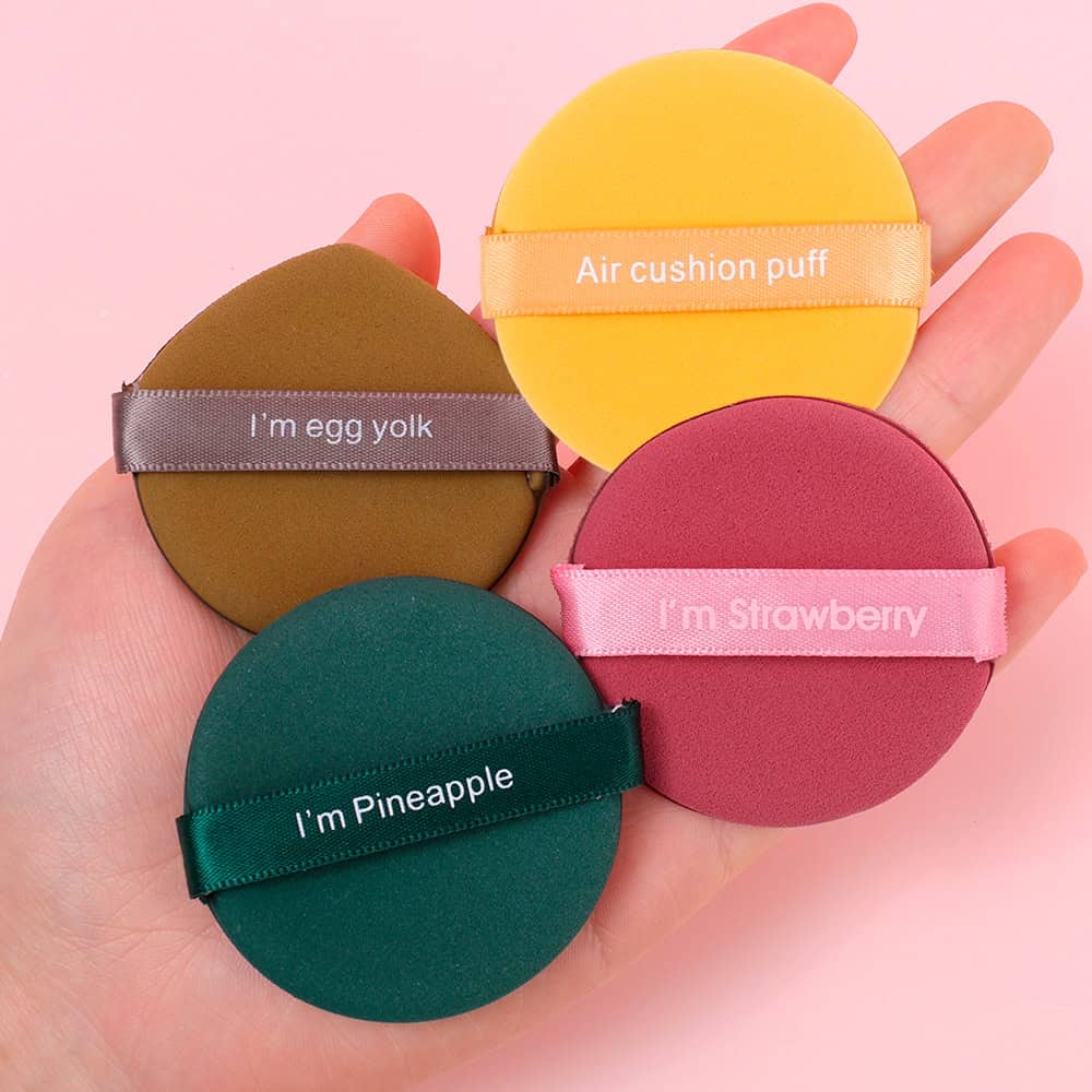 Colorful cosmetic sponges with playful labels and ribbons, ideal for makeup application, available at Monalisa Medical Store for beauty and skincare enthusiasts.