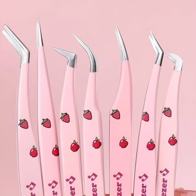 Pink strawberry-themed dental tools with ergonomic handles on a pink background, ideal for professional dental care and orthodontic procedures.
