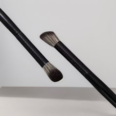 Fluffy makeup brushes with black handles floating against a light gray background for skincare and beauty application.