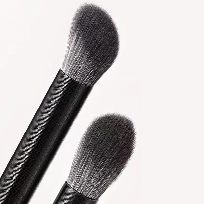Soft powder makeup brushes with black handles and synthetic bristles for professional cosmetic application.