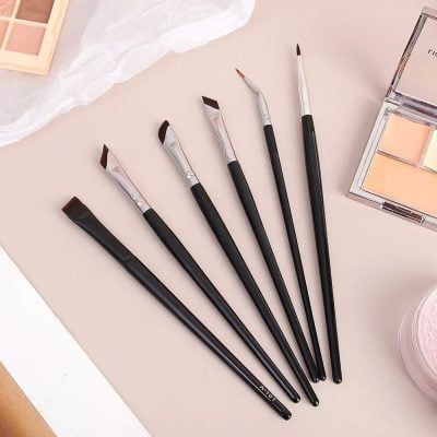 Soft pink makeup brushes set with black handles, ideal for beauty and cosmetic application. Perfect for professional and personal use in makeup routines.