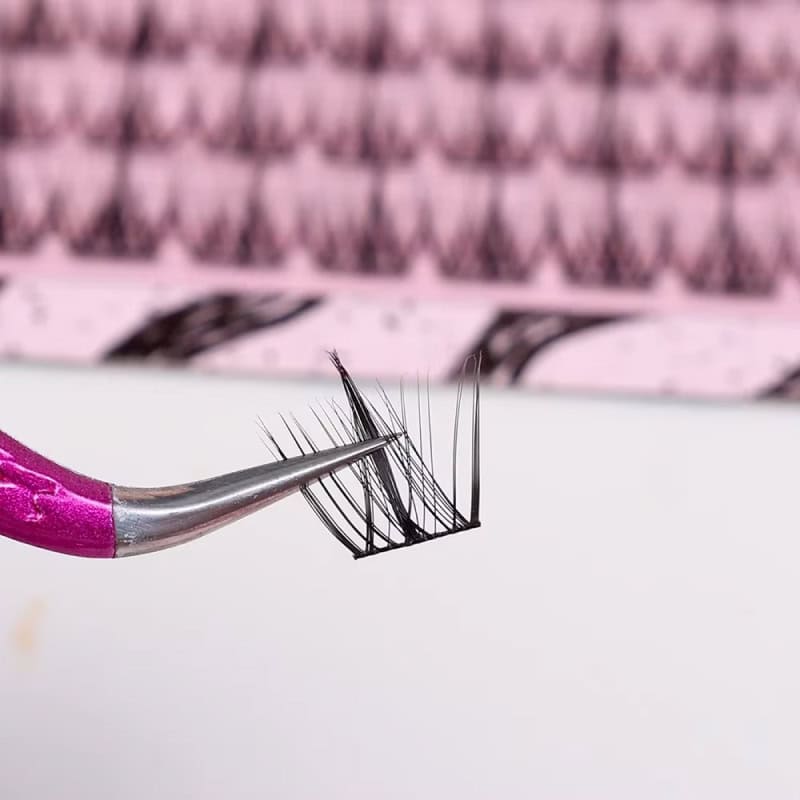Precision eyelash extension tweezers holding artificial eyelashes for beauty and cosmetic procedures.