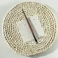 Natural stone makeup palette with brush on woven placemat, luxury cosmetic tools, Monalisa Store skincare accessories, high-quality beauty essentials for women alt text.