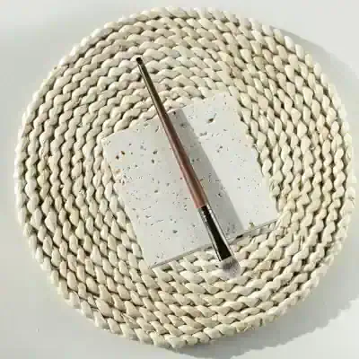 Natural stone makeup palette with brush on woven placemat, luxury cosmetic tools, Monalisa Store skincare accessories, high-quality beauty essentials for women alt text.