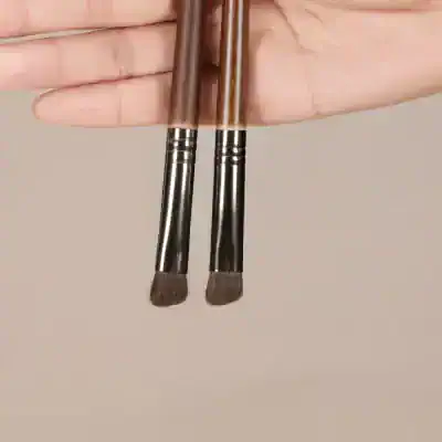 High-quality makeup brushes held by hand, ideal for professional cosmetic application, beauty products, and skincare routines. Perfect for achieving flawless makeup looks.