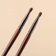 Soft makeup brushes with wooden handles and nickel ferrule tips, ideal for professional and daily cosmetics application, showcased against a neutral beige background.