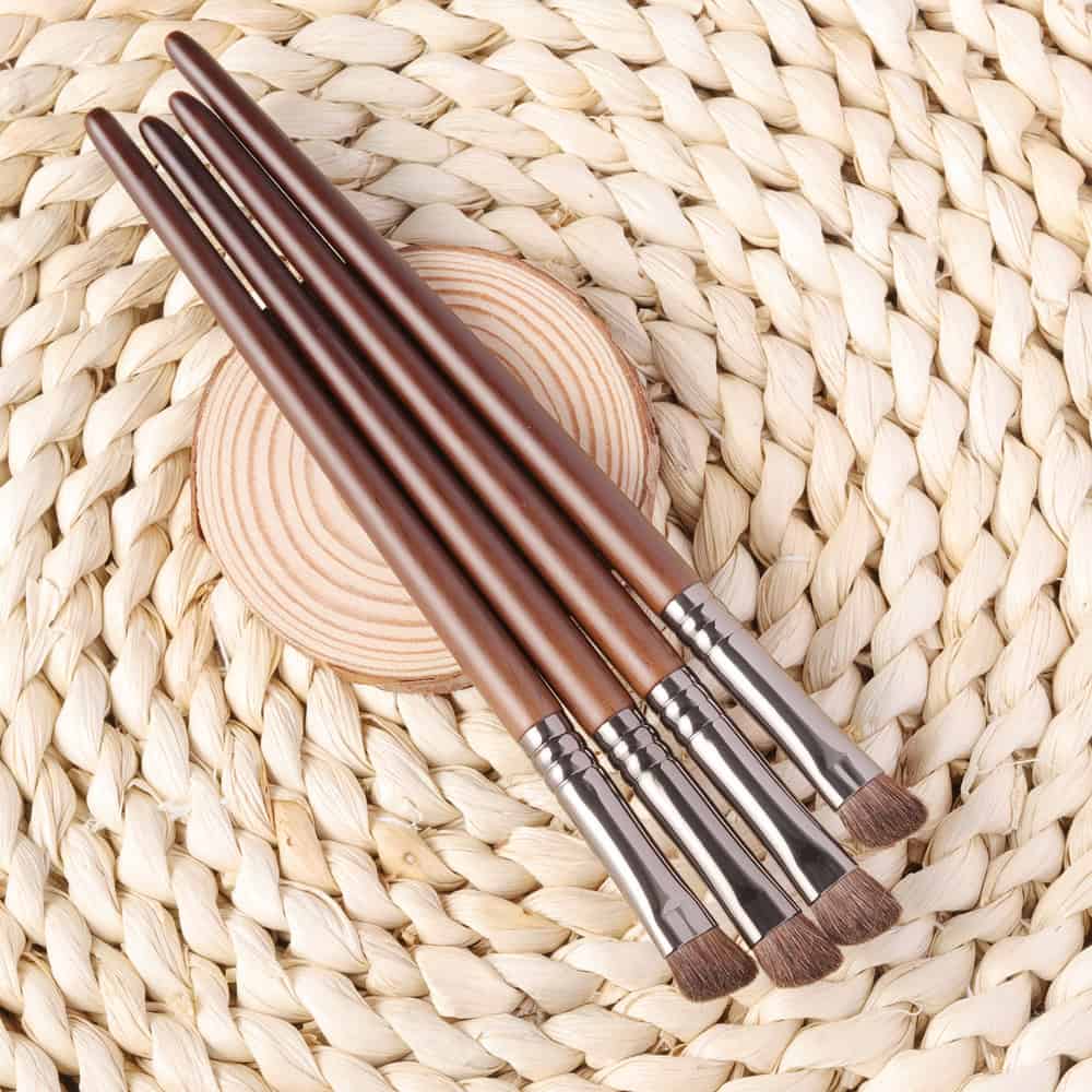Soft brown makeup brushes with wooden handles arranged on a woven straw surface for skincare, beauty, and cosmetic application. Ideal for professional and personal makeup use from Monalisa Store.
