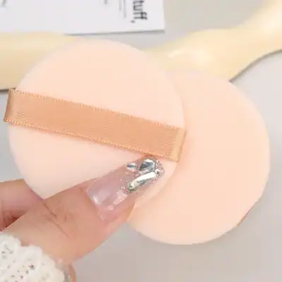 Silicone makeup removal sponge with beige ribbon for gentle cleansing, ideal for face skincare routines. Soft, reusable, and perfect for removing makeup and impurities efficiently.