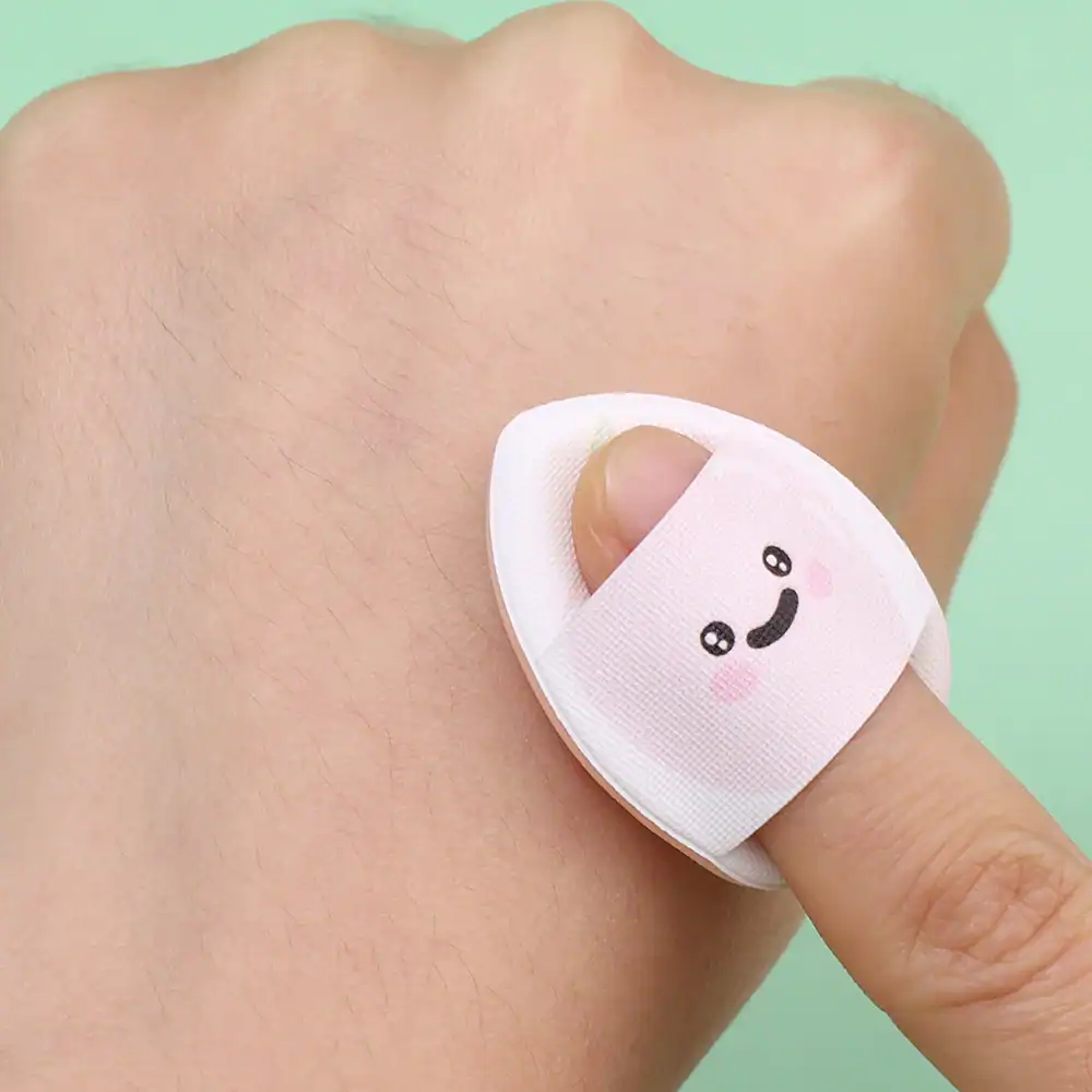 Bandage with cute smiling face on finger, soothing wound care, gentle skin protection, Monalisa Medical store quality, pediatric and adult first aid supplies.