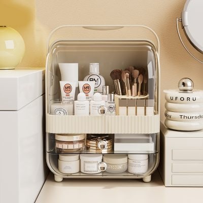 Soft modern cosmetic storage case with skincare, makeup brushes, and beauty products on a beige wall background.