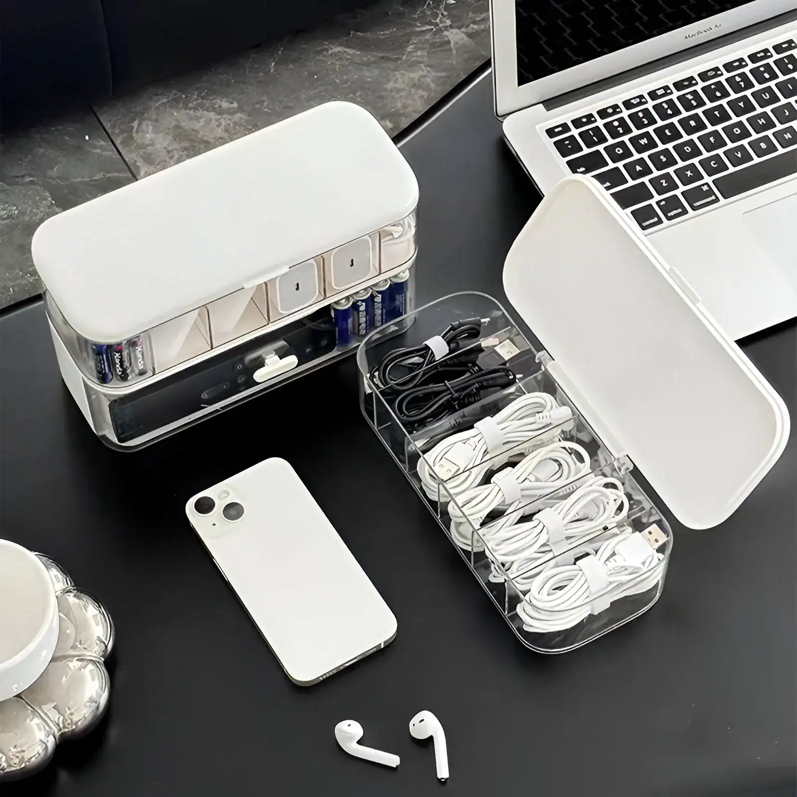 Charging station with multiple cables, power bank, and a smartphone on a desk, ideal for modern tech accessories and electronic devices.