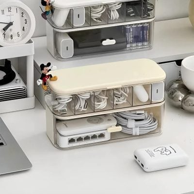 Organized cable storage container for electronics and accessories, perfect for home office or workspace organization.