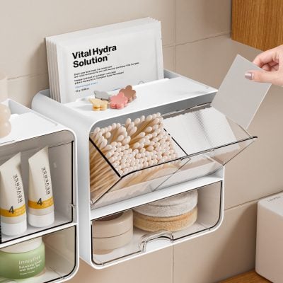 Elta text: organized beauty and skincare products on Monalisa Store shelf, including cotton swabs, creams, and skincare treatments in a modern, minimalist bathroom setting.