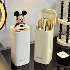 Miniature Mickey Mouse figurine on a sleek white cosmetic container, showcasing stylish beauty and makeup storage solutions; ideal for beauty aficionados and interior decor.