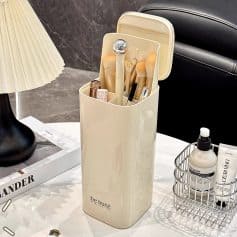 Soft beige beauty tools organizer with skincare and makeup brushes on a clean white vanity, featuring a sleek design for modern beauty routines.