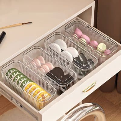 Assorted colorful and black contact lenses stored in clear plastic organizers on a white desk for eye care and vision enhancement at Monalisa Store.