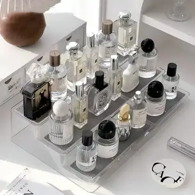Perfume bottles and skincare products displayed on a clear acrylic tray at Monalisa Store, emphasizing luxury fragrance and beauty essentials for women.
